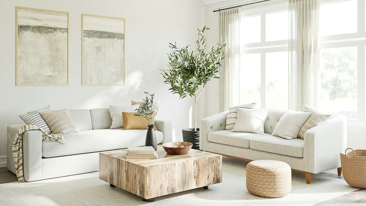 Salon lumineux avec deux canapés crème à assise profonde, table basse en bois et olivier